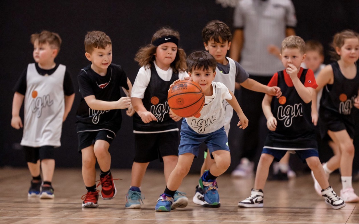 Young kids playing basketball in IGN jerseys